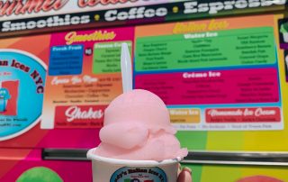 Pink Italian ice in cup in front of Andy's Italian Ice truck